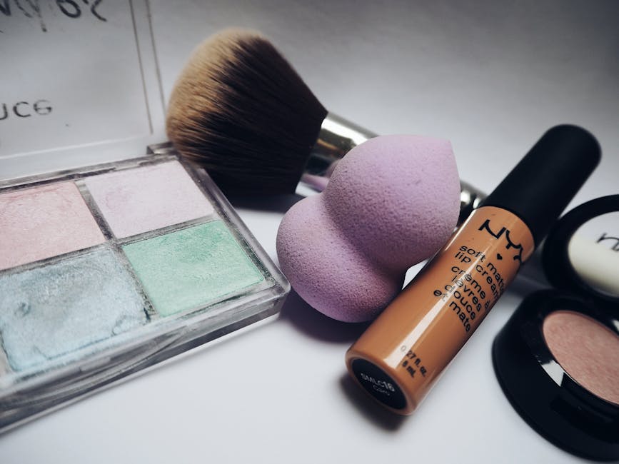 A flat lay showcasing various makeup essentials including brushes, sponges, and cosmetics